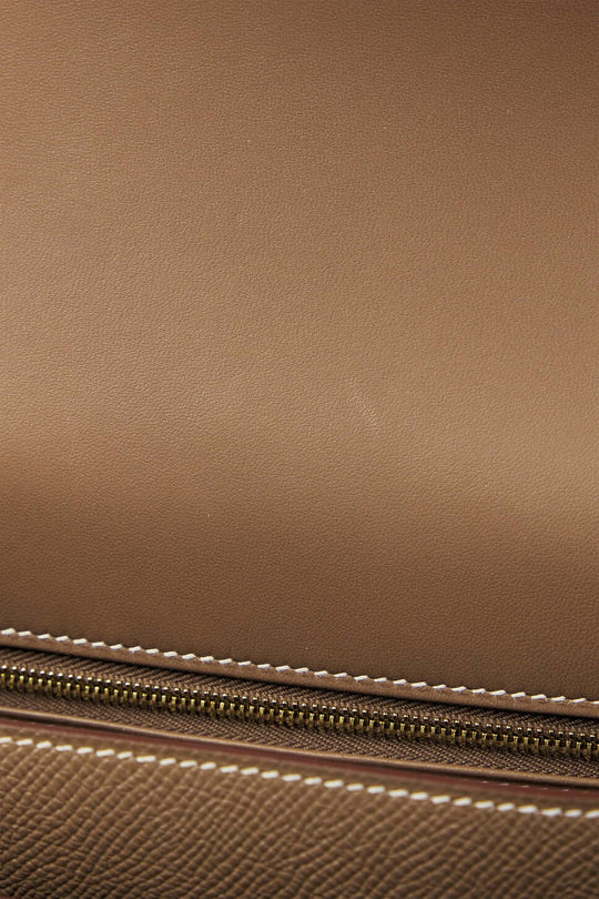 Hermès Constance Mini beige luxury bag with gold zipper detailing and classic stitching, perfect for stylish everyday use.