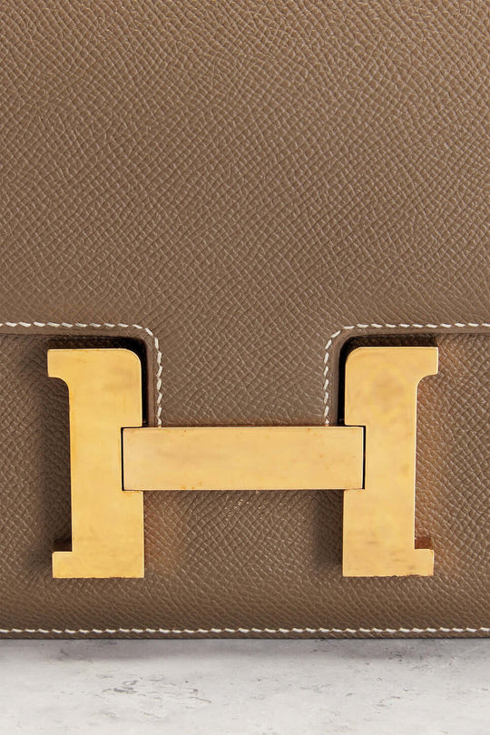 Hermès Constance Mini beige luxury bag for women featuring iconic gold H-shaped clasp, a timeless fashion statement.