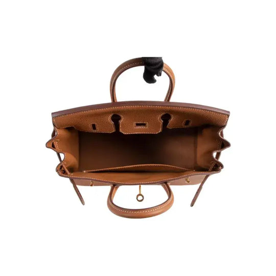 Interior view of brown HERMES Birkin 25 leather handbag showcasing spacious compartments, ideal luxury bag for women.