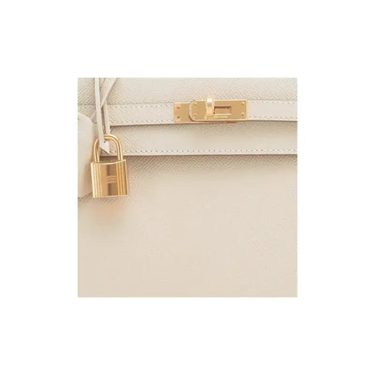 Hermès Kelly 25 luxury bag for women in nata white with gold hardware features a signature padlock and elegant design.
