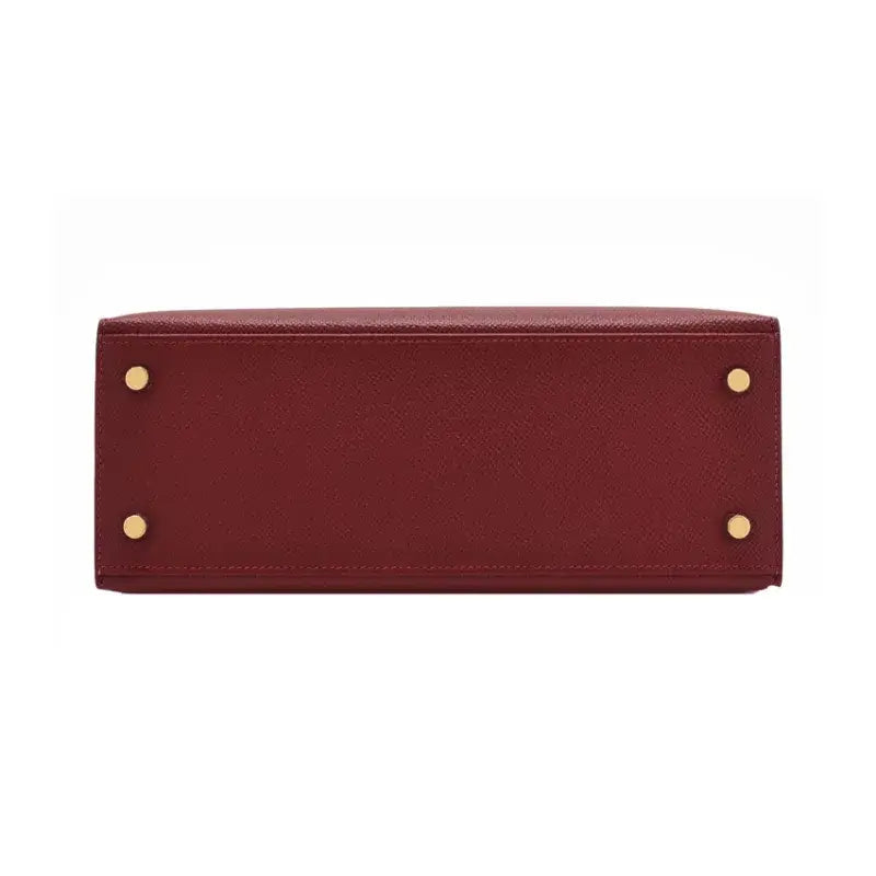 Hermes Kelly red Togo leather bag base showing gold hardware, an elegant and timeless luxury bag for women.