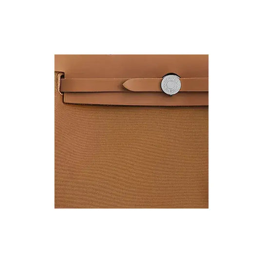 Close-up of Herbag Zip 31 in rich brown canvas featuring a chic clasp, a stylish luxury bag for women offering timeless elegance.