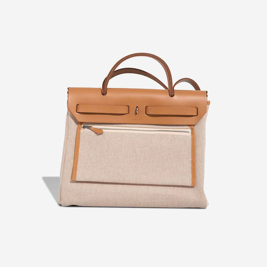HERMÈS Herbag 31 Vache Hunter Sable Naturel is a luxury bag for women featuring durable canvas and elegant leather handles, ideal for everyday use.