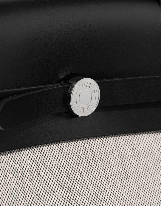 Hermes Herbag 31 bag close-up featuring silver hardware, black canvas and calfskin leather, luxury bag for women.