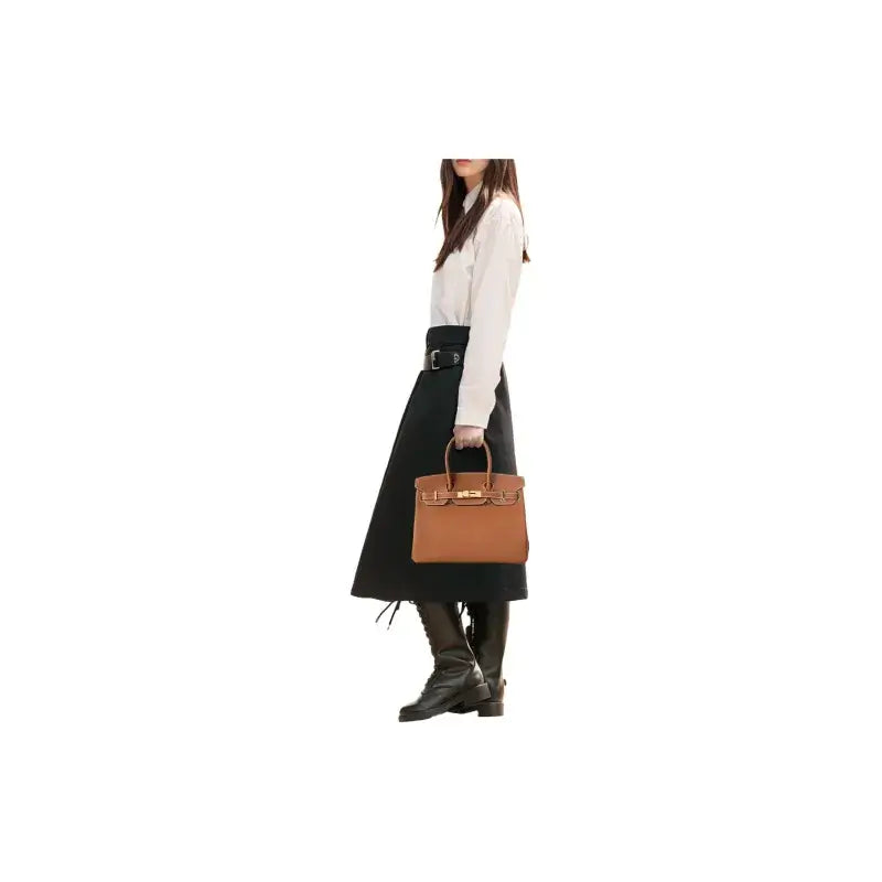 Hermes Birkin 25 brown tote bag in togo leather held by a woman in a stylish outfit, a timeless luxury bag for women.