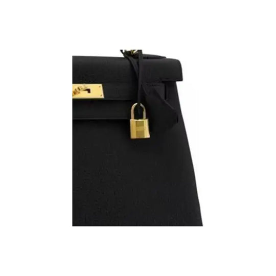 Hermès Kelly 25 black Togo leather handbag showing a gold lock detail, a classic luxury bag for women.