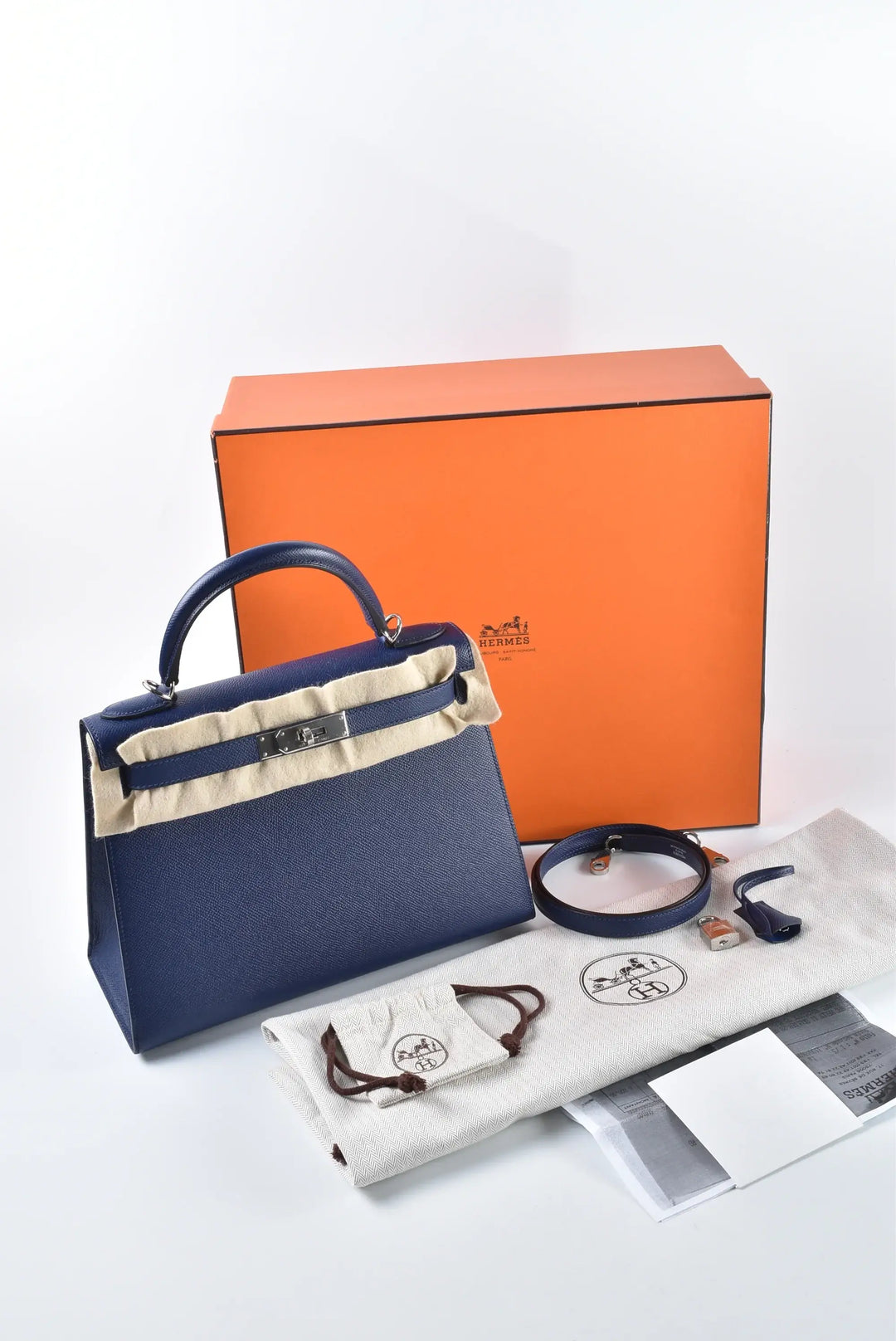 HERMES Kelly Bag in navy Epsom leather with silver hardware, accompanied by dust bag and packaging, ideal designer handbag for women.