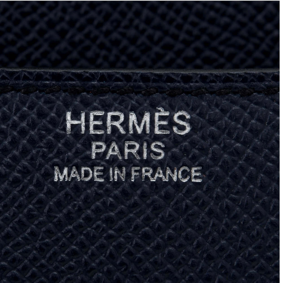 Hermès Paris logo embossed on black leather, symbolizing luxury bag craftsmanship and timeless fashion.