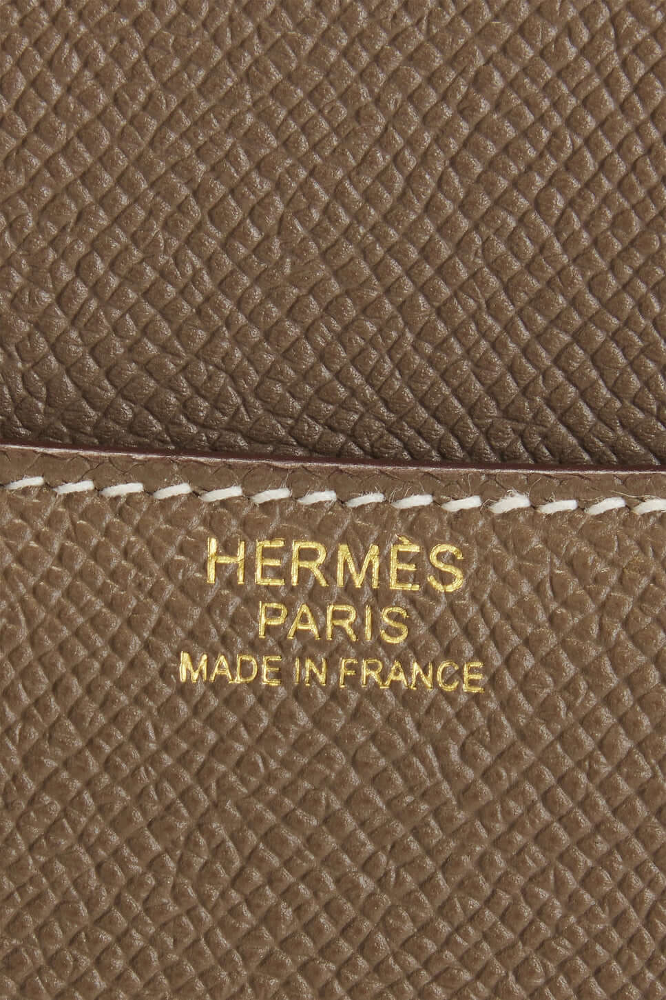 Hermès logo on beige leather, showcasing craftsmanship of luxury bag for women, highlighting Made in France quality.