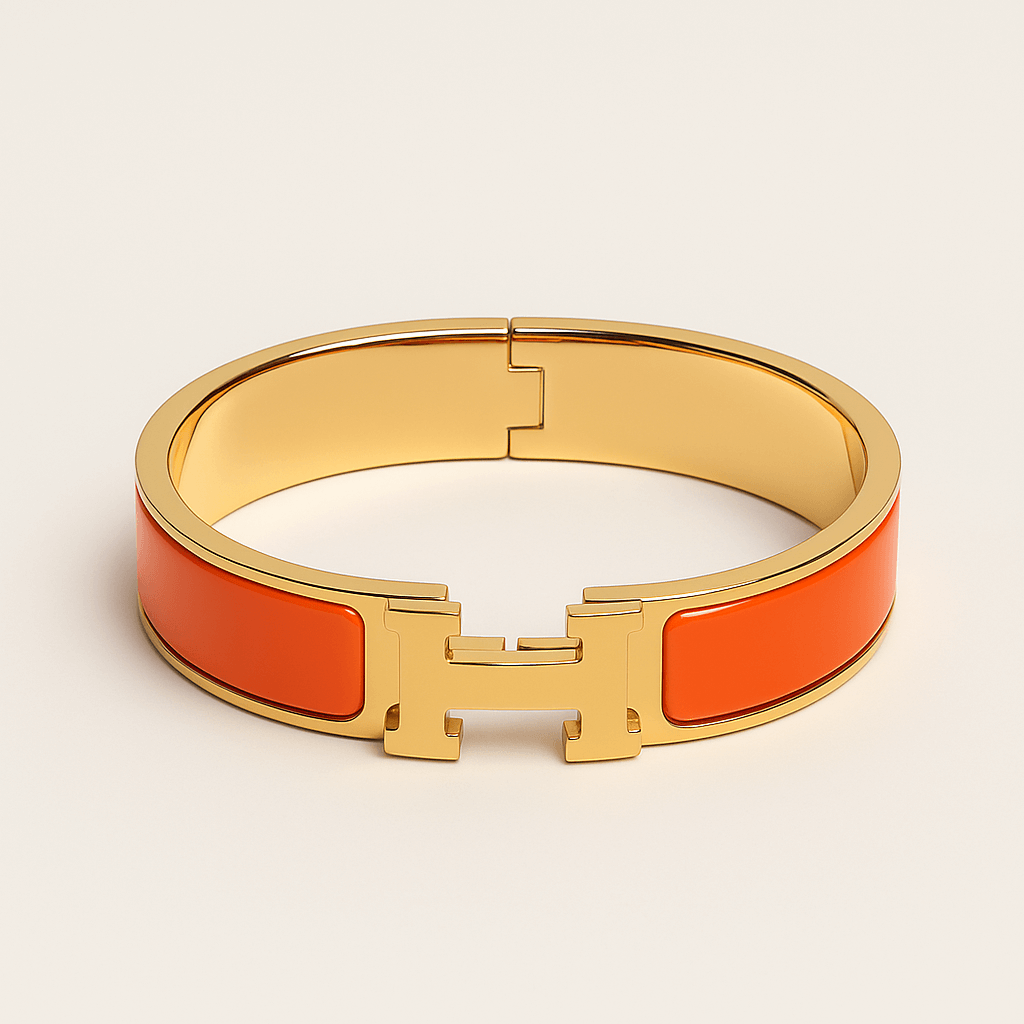 Hermes Clic HH bracelet 12MM in orange with gold H clasp, a luxury fashion accessory, perfect for layering or standalone wear.