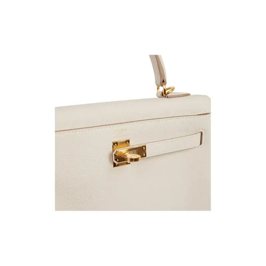 HERMES Kelly 25 cream Togo leather handbag with elegant gold clasp, a luxury bag for women showcasing timeless fashion.