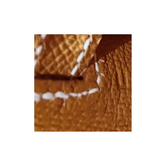 close-up of luxurious cow brown Epsom leather with white stitching showcasing high-quality craftsmanship of designer handbag
